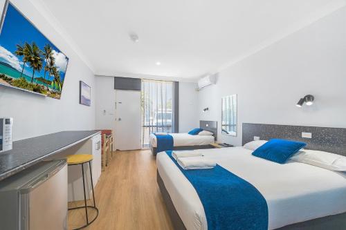 a hotel room with two beds and a kitchen at Plainsman Motel in Forbes