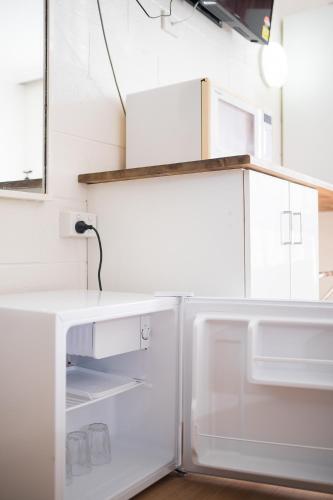 a white refrigerator with its door open in a kitchen at Plainsman Motel in Forbes