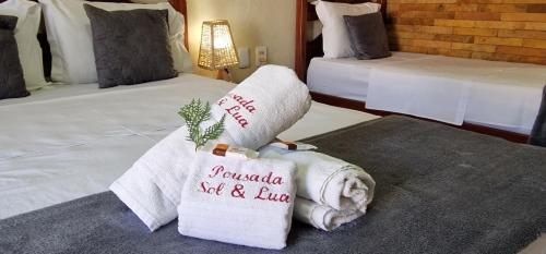 a hotel room with two beds with towels at Hotel Pousada Sol & Lua in Paracuru