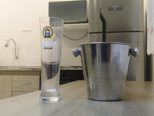 a glass of water next to a bucket on a kitchen counter at BORA BORA RESIDENCE in Joinville