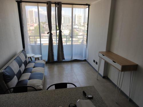 sala de estar con sofá y ventana grande en Departamento arriendo diario, en Santiago