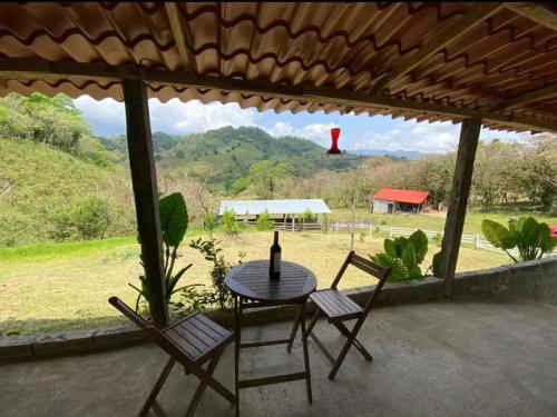 a table and chairs on a patio with a view of a field at Cabaña SAN AGUSTÍN in Xilitla