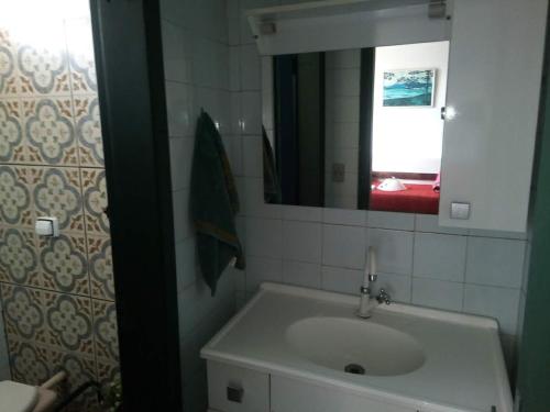 a bathroom with a sink and a mirror at Hospedagem com carinho! in Curitiba