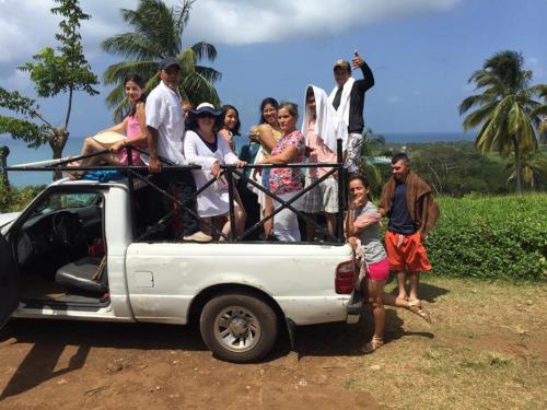 een groep mensen die op de achterkant van een truck staan bij Jackson Guest House in Corn Island