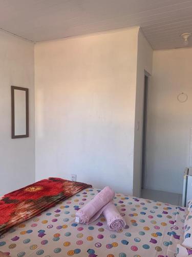 a bedroom with a bed with a pink roll on it at Hospedaria da Cris in Salvador
