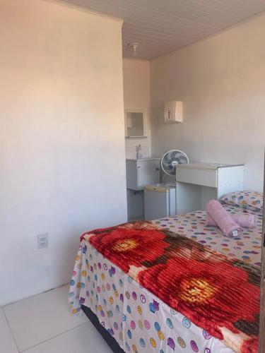 a bedroom with a bed with a colorful blanket at Hospedaria da Cris in Salvador
