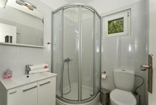 a bathroom with a shower and a toilet and a sink at Apartments by the sea Seget Vranjica, Trogir - 1037 in Seget Vranjica
