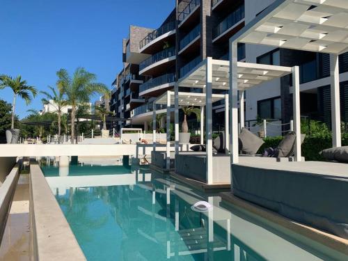 a swimming pool in front of a building at LUXURY spacious Condo Option with 1 or 2 or 3 Bedrooms, PGA Golf, Gym, Kay Beach Club in Kaan Ha Akumal in Akumal