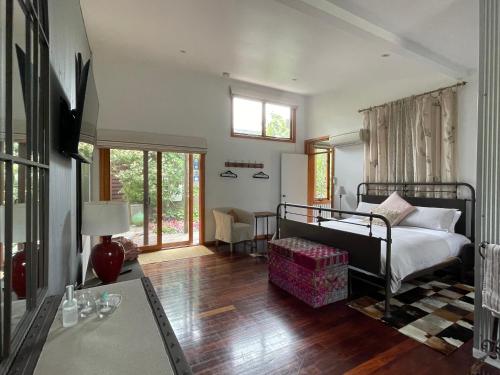 ein Schlafzimmer mit einem Bett und ein Wohnzimmer in der Unterkunft The Studio - Yarra Valley in Yarra Glen