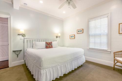 a white bedroom with a bed and a window at Palm Gardens in Key West