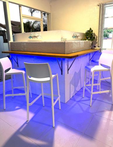 a counter with three chairs and a table with a counter top at Home in Miami in Miami
