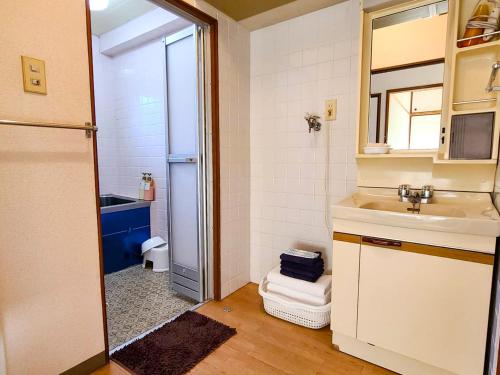 Baño pequeño con lavabo y espejo en Weekly Hotel Kokura, en Kitakyushu