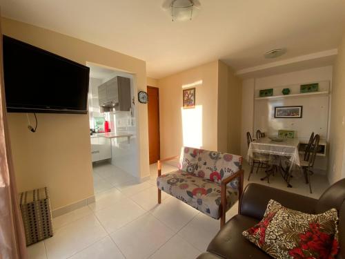 Apartamento temporada com garagem, Wi-Fi, Netflix في غواراباري: غرفة معيشة مع أريكة وغرفة طعام