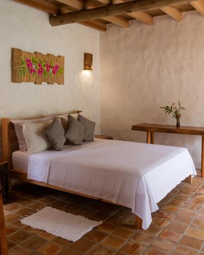 a bedroom with a white bed with flowers on the wall at Villa Sagui Trancoso in Trancoso
