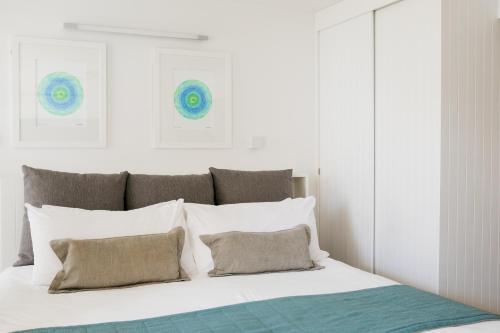 a bedroom with a white bed with white pillows at Netanya Noosa Beachfront Resort in Noosa Heads