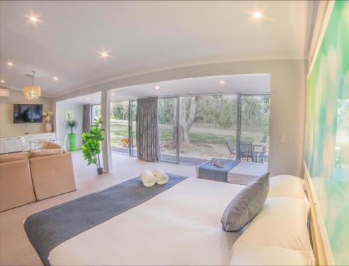 a bedroom with a large bed and a living room at Noosa North Shore Retreat in Noosa North Shore