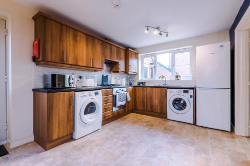 a kitchen with white appliances and wooden cabinets at 3 Bedroom! 3 Toilets! Contractors and Groups! Free Parking! Driveway! NEW BUILD HOUSE! in Burton upon Trent