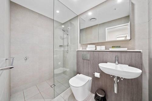 a bathroom with a toilet and a sink and a shower at Commodious 2 Bedroom APT in OP in Sydney