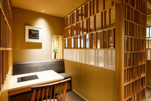 biblioteca con escritorio de madera y estantería de libros de madera en Yuraku Kinosaki Spa & Gardens, en Toyooka