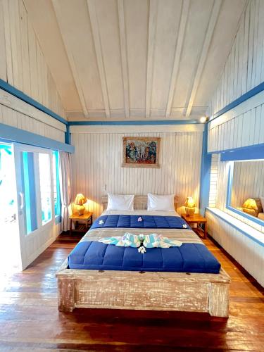 una camera da letto con un grande letto con lenzuola blu di Youpy Bungalows a Gili Air