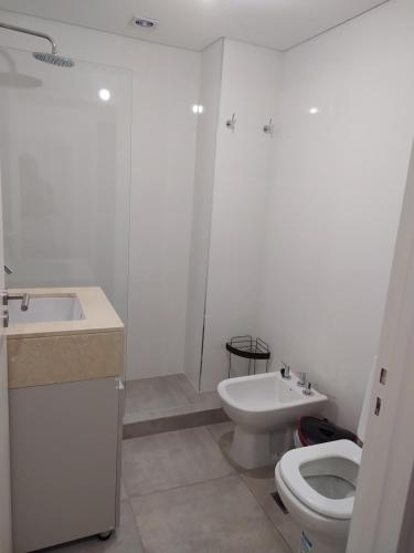 a white bathroom with a toilet and a sink at Mirador La Viña in Salta