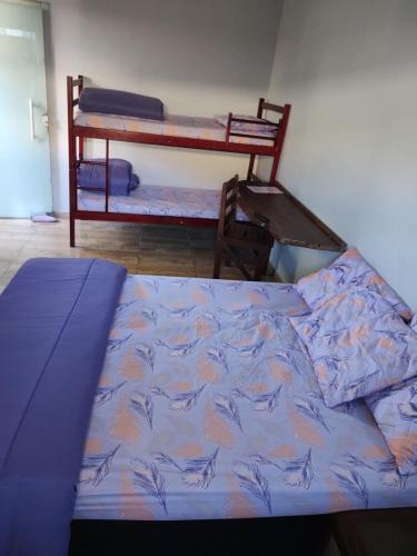 een bed met een blauw dekbed en 2 stapelbedden bij Kitnet em Cabo Frio 02 in Cabo Frio