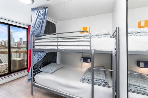 a room with three bunk beds and a window at Samesun Toronto in Toronto
