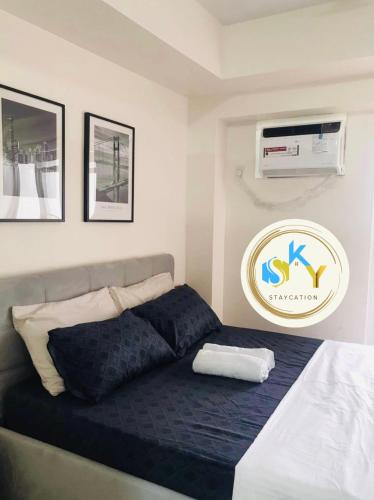 a bedroom with a bed with a blue blanket at 1BR Condo Unit at Celandine Condominium Near Ayala Cloverleaf Mall in Manila