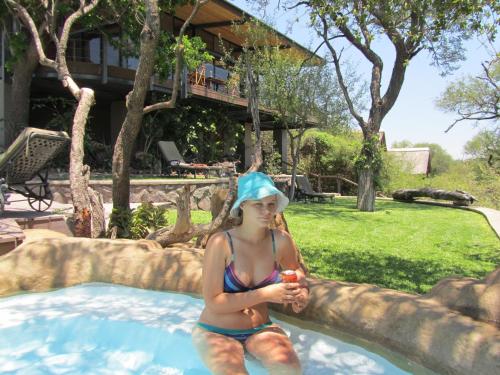 a girl in a swimming pool with a towel on her head at Greenfire Game Lodge in Balule Game Reserve