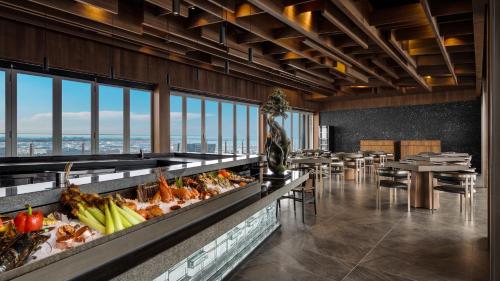 高雄的住宿－TAI Urban Resort 承億酒店，一间带桌椅的餐厅以及一间自助餐