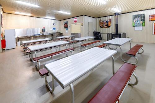 une salle de classe avec des tables et des chaises dans une cafétéria dans l'établissement BIG4 Opal Holiday Park, à Lightning Ridge