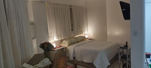 1 dormitorio con 1 cama y una ventana con 2 velas en APARTAMENTO OCHAVA Promos x paquetes Conversión Dolar Oficial en Buenos Aires