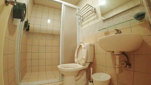 La salle de bains est pourvue de toilettes, d'un lavabo et d'une douche. dans l'établissement 心旅地圖青年旅館, à Changhua