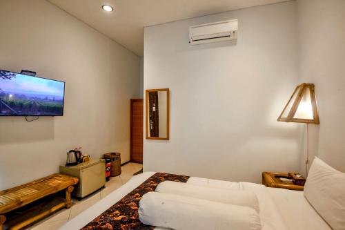 a living room with a white couch and a flat screen tv at Rumah Mertua Heritage in Yogyakarta