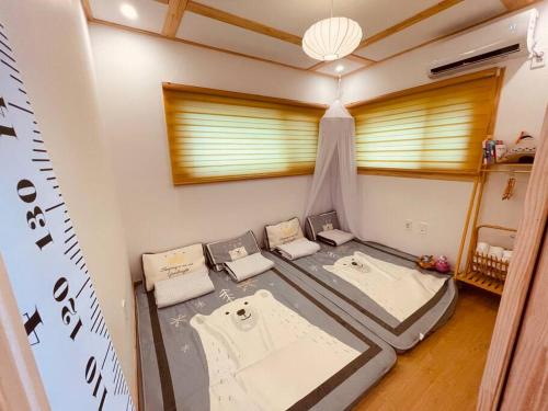 a room with two beds and a window at bebe angpang 2 in Seogwipo