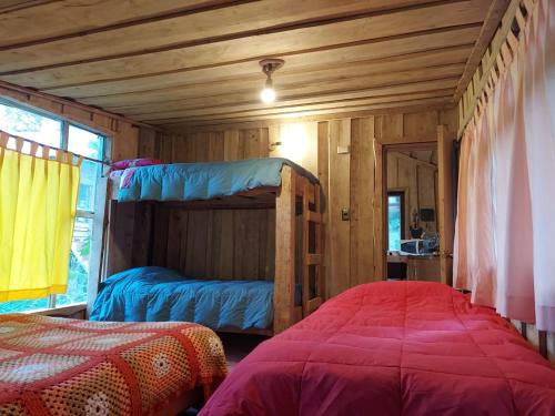 a bedroom with two bunk beds and a window at Cabañas Cauchao Chaitén in Chaitén