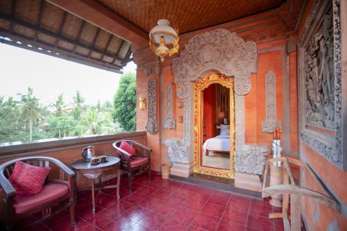 a room with a balcony with a table and chairs at Gayatri in Ubud