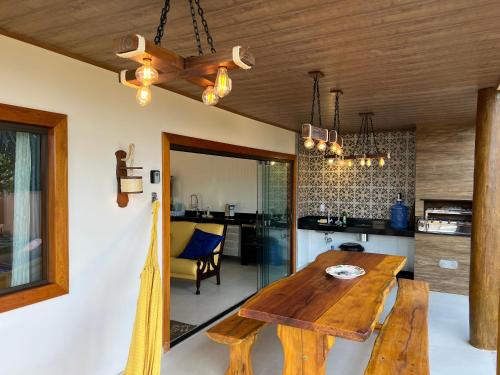 uma sala de jantar e cozinha com uma mesa de madeira em Recanto Bela Vista II em Costa Dourada