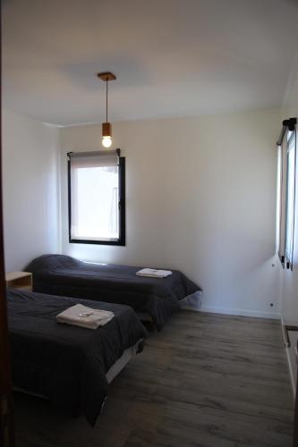 a room with two beds and a window at Casa 3 ambientes - FARO NORTE - in Mar del Plata