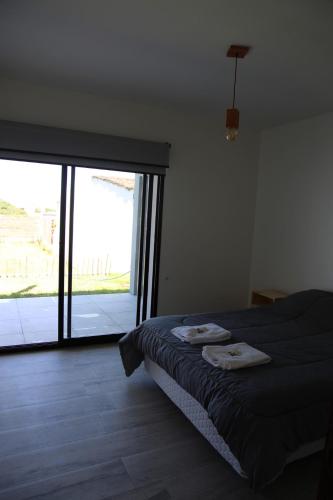 1 dormitorio con cama y ventana grande en Casa 3 ambientes - FARO NORTE - en Mar del Plata