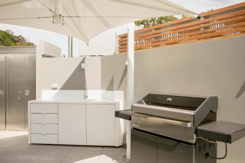 a barbecue grill with an umbrella in a kitchen at Netanya Noosa Beachfront Resort in Noosa Heads