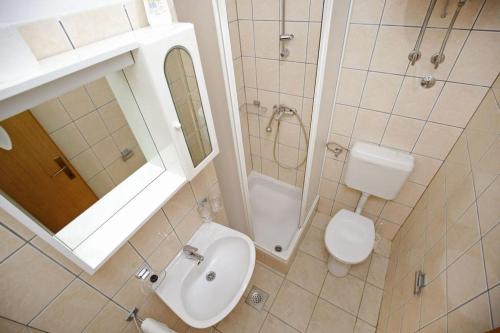 La salle de bains est pourvue d'un lavabo, de toilettes et d'un miroir. dans l'établissement Holiday apartment in Privlaka with sea view, balcony, air conditioning, WiFi 3598-5, à Privlaka