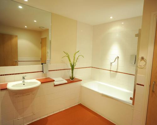 a bathroom with a sink and a tub and a toilet at PREMIER SUITES Bristol Redcliffe in Bristol