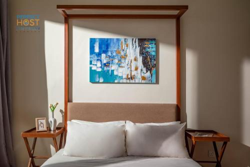 Una cama en una habitación de hotel con un cuadro encima. en Timurbay Beachfront by Perfect Host en Kuantan