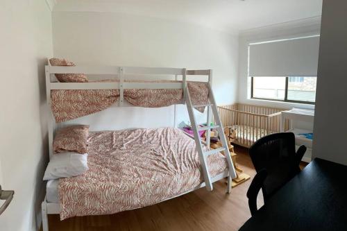 a bedroom with two bunk beds and a crib at Harrington Getaway in Harrington