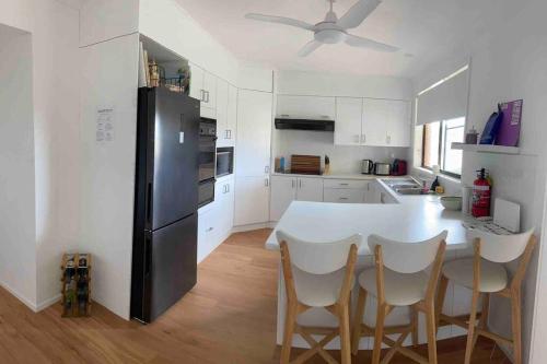 a kitchen with a black refrigerator and white cabinets at Harrington Getaway in Harrington