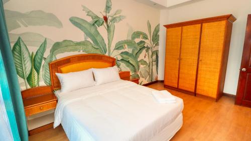 ポートディクソンにあるLong Sands Port Dicksonの白いベッド1台付きのベッドルーム1室(壁に絵画付)