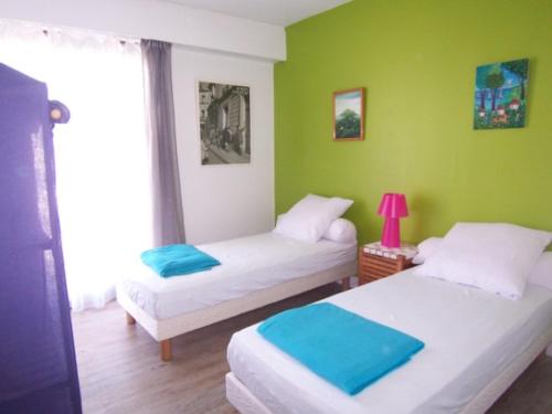 deux lits dans une chambre aux murs verts dans l'établissement Superbe T3 Centre Arcachon avec Parking et Wifi - FR-1-374-59, à Arcachon