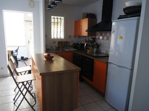 une cuisine avec un réfrigérateur blanc et un comptoir dans l'établissement Maison familiale avec jardin, proche Dune du Pyla et parcs, idéale pour vacances ensoleillées - FR-1-319-362, à Gujan-Mestras