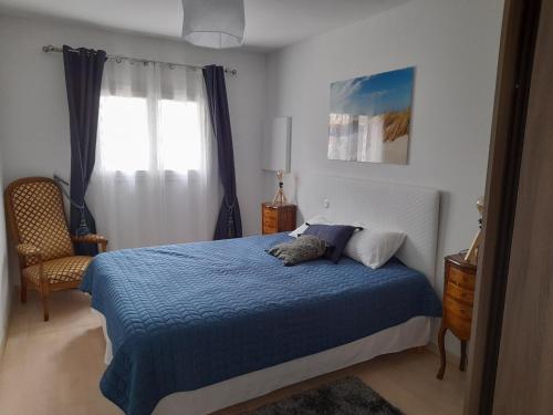 une chambre avec un lit bleu et une fenêtre dans l'établissement Maison familiale avec jardin, proche Dune du Pyla et parcs, idéale pour vacances ensoleillées - FR-1-319-362, à Gujan-Mestras